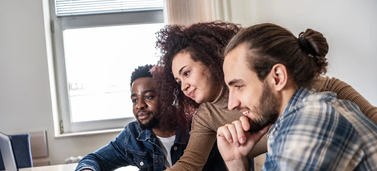 Client Review: three people leaning in to look at a laptop together