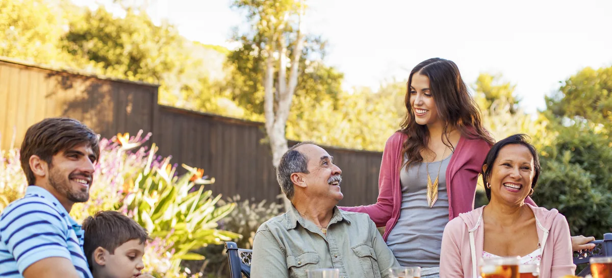 Garden Lunch: a family laughing together around a table in a sunny garden