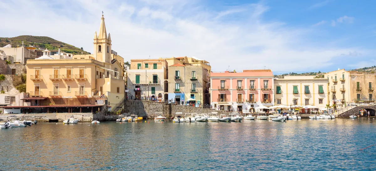 Harbor Waterfront: colorful buildings and a bell tower along a harbor with small boats