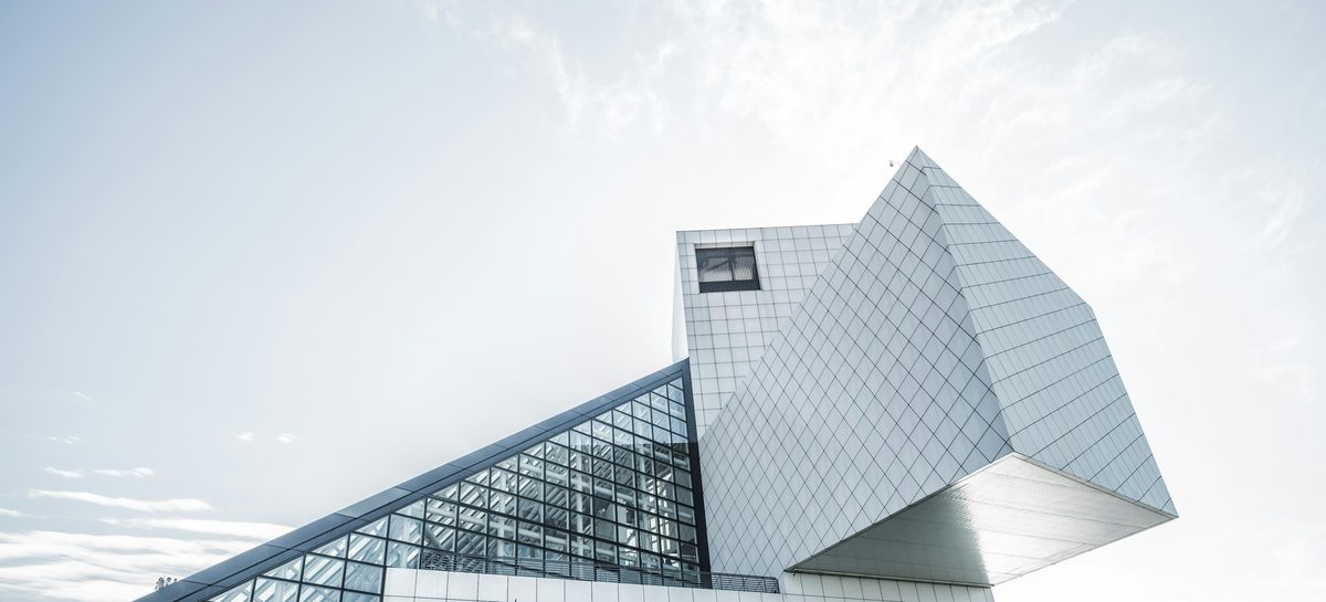 Geometry of Light: a white angular building with a glass facade against a bright sky