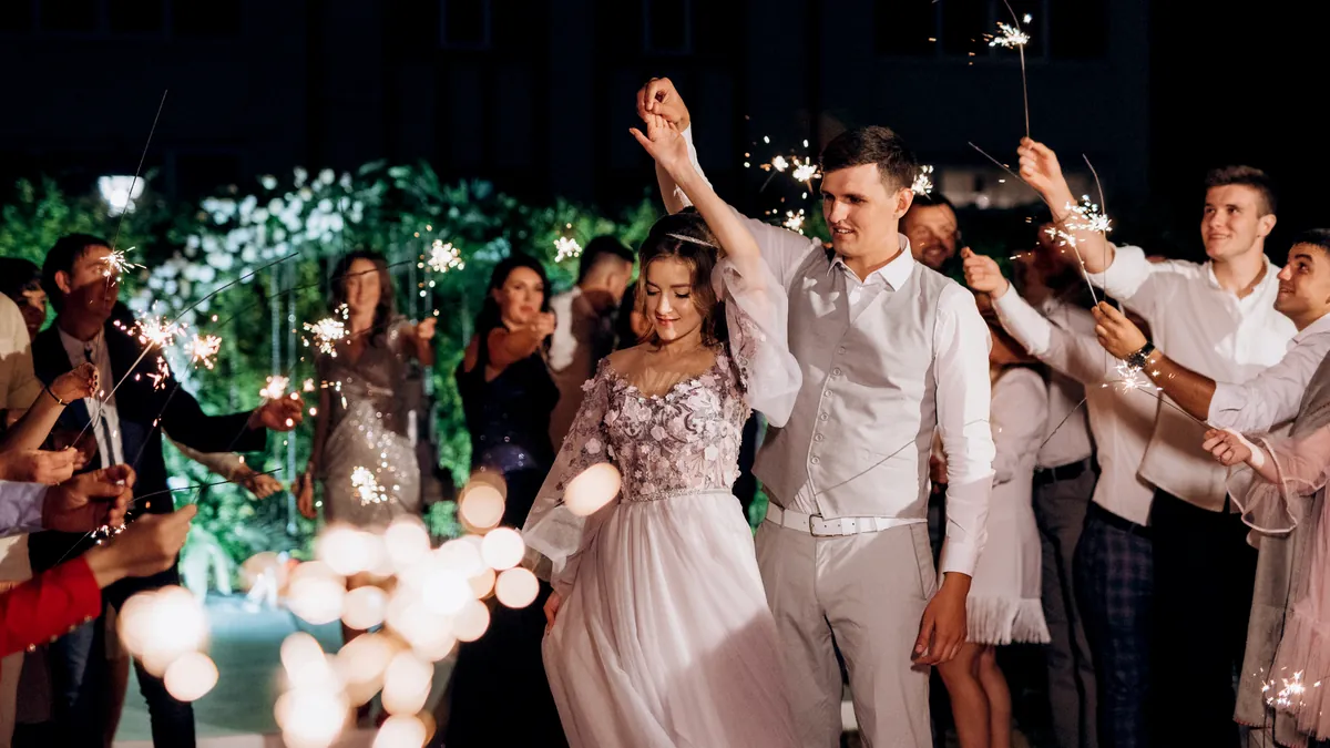Guests holding sparklers as the couple walks through