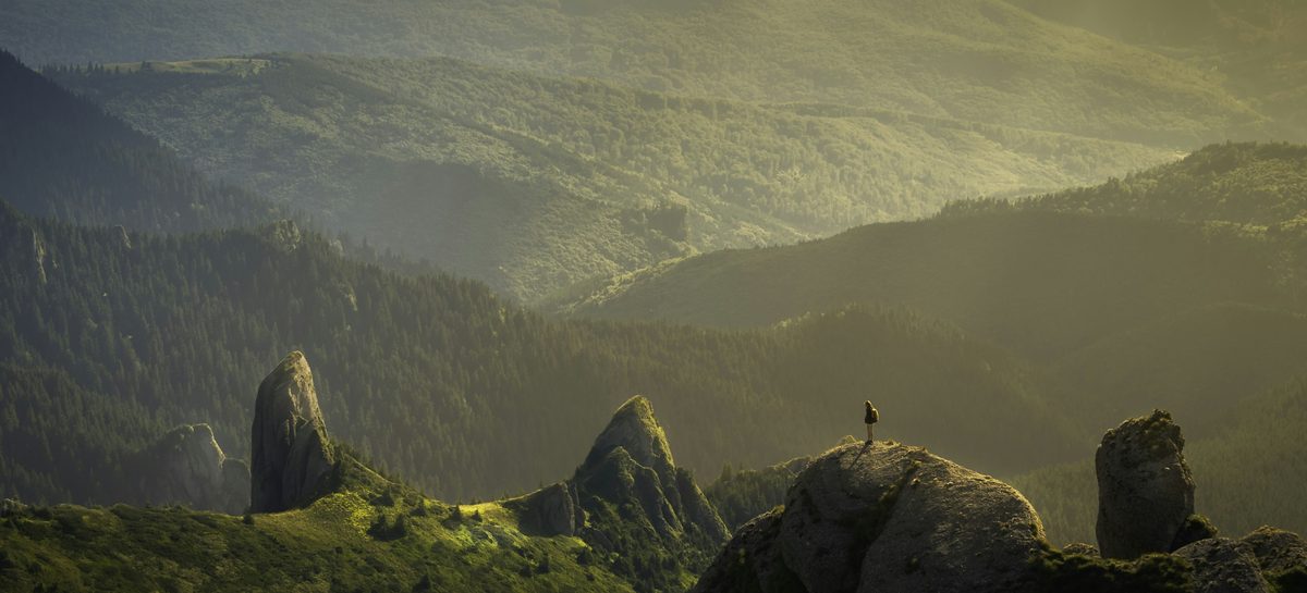 Mountain Light, Natural Landscape: sunlit mountain ridges with sculpted rocks and a tiny figure