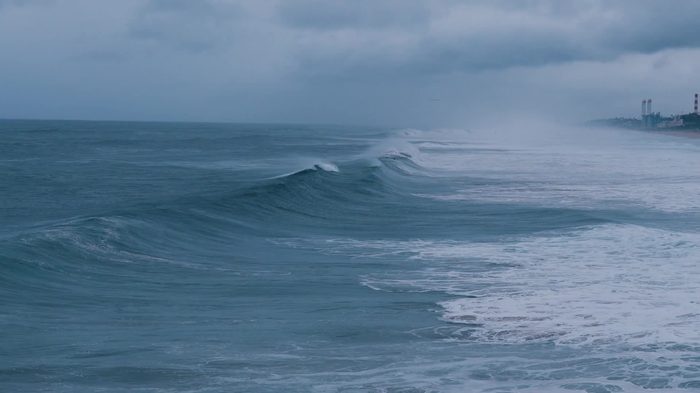 A frame from Client Story in Motion: ocean surf under a gray sky