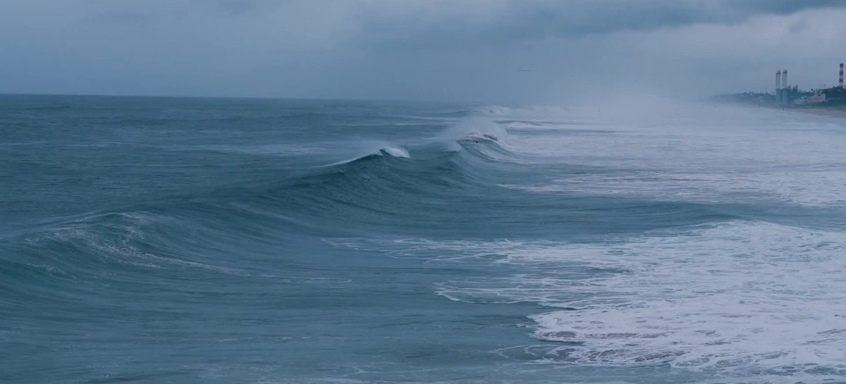 A frame from Client Story in Motion: a wave curling across a gray-blue sea